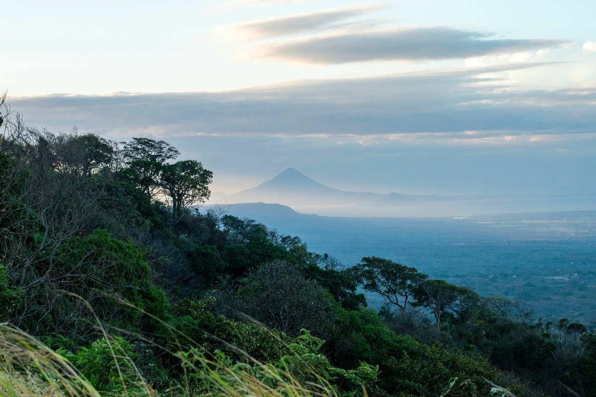 Wide view of the Nicaraguan highlands at dusk, with a volcano rising in the distance